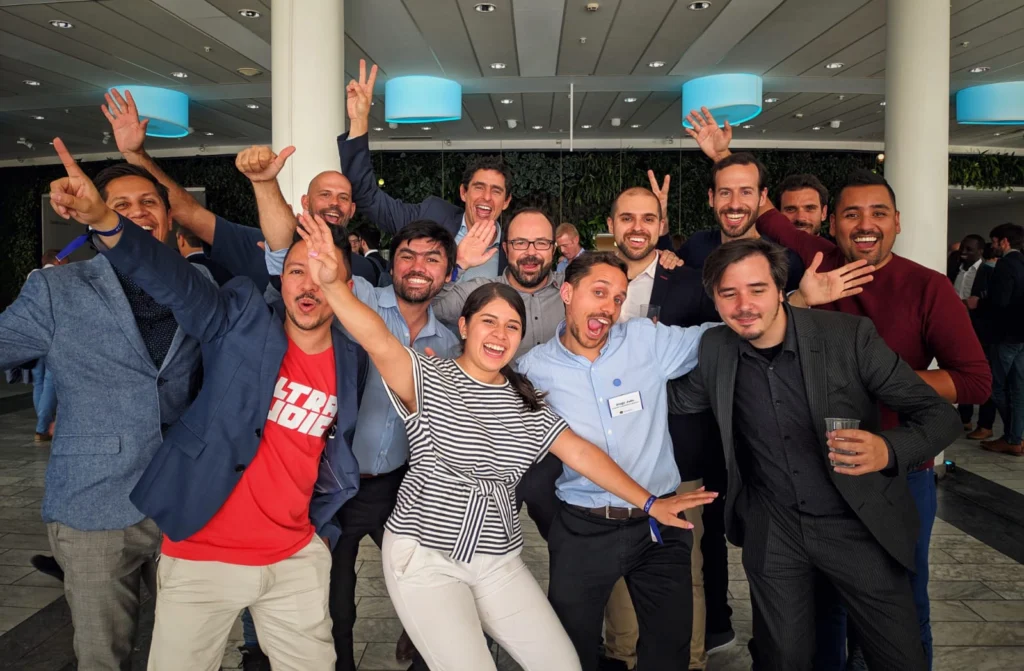 Grupo de personas celebrando y posando de manera alegre al final de un evento.