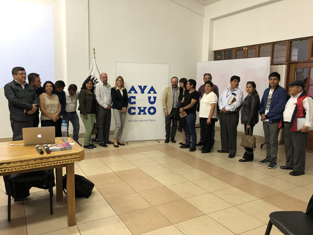 Grupo de participantes y facilitadores en una sesión de trabajo en Ayacucho, Perú, con Juan Pastor Bustamante entre ellos.