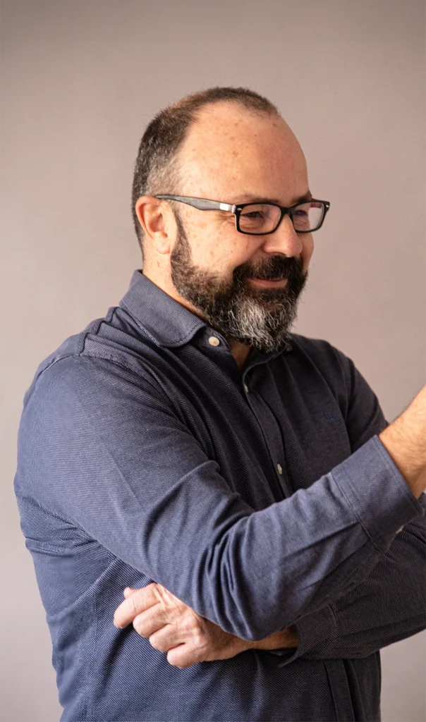 Juan Pastor Bustamante sonriendo y gesticulando durante una conversación, en un retrato de medio cuerpo.